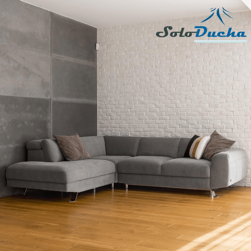 Salón con suelo de madera y sofá y pared en color gris
